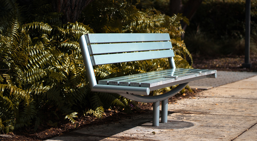 A park bench allows one or more people of different sizes to sit or recline comfortably